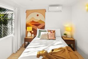 una camera da letto con letto, cuscini e finestra di Wait-a-While - Family Getaway with Heated Pool a Clifton Beach