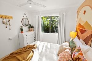 una camera bianca con un letto e una finestra di Wait-a-While - Family Getaway with Heated Pool a Clifton Beach