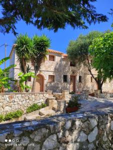 a stone house with palm trees and a stone wall at Monte e Mare in Minia