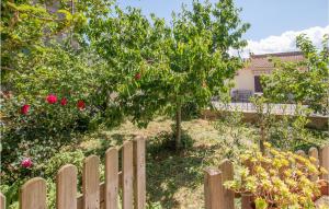 a wooden fence with a tree in a garden at 1 Bedroom Cozy Home In Montegiovi in Montegiovi +10 photos