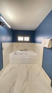 ein Bad mit einer Badewanne in einer blauen Wand in der Unterkunft The Fremont Inn in Monterey