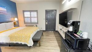 ein Hotelzimmer mit einem Bett und einem TV in der Unterkunft The Fremont Inn in Monterey