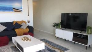 uma sala de estar com uma grande televisão de ecrã plano em #24 K I G Heights, Kings Beach - Stunning Views em Caloundra