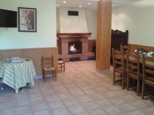 a dining room with a table and a fireplace at Angoiko Etxea in Bacáicoa