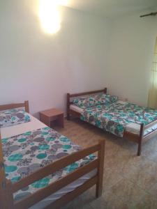 two beds sitting in a room with at Vito Apartments Sutomore in Sutomore