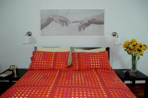1 dormitorio con 1 cama roja y 2 almohadas rojas en Apartment Oltremarestudios, en Nápoles