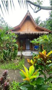 a house in the middle of a garden at Kubu Artha Bungalow Nusa Penida in Nusa Penida