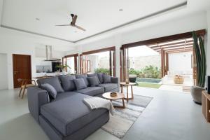 a living room with a gray couch and a table at Cosy and Luxurious Villa Sentosa Seminyak in Seminyak
