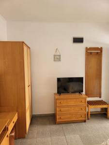 a room with a tv and a wooden dresser at Pension Edelweiss in Eforie Sud