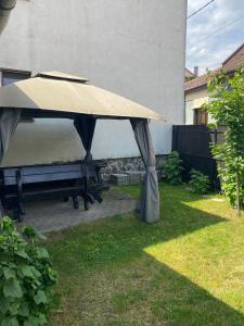 a picnic table with a tan umbrella in a yard at Private House Citadela Tg.Mures in Târgu-Mureş