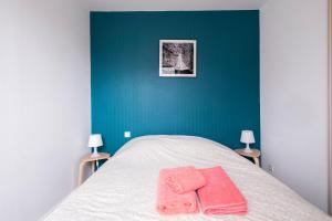 - une chambre avec un lit et 2 serviettes roses dans l'établissement Gîte Terracotta de Segré ✰ cuisine ✰ chambre (lit queen size) ✰ salon, à Segré