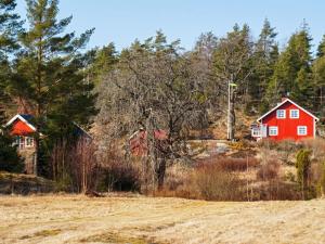 uma casa vermelha numa colina com árvores em Holiday home STRÖMSTAD XXVIII em Strömstad