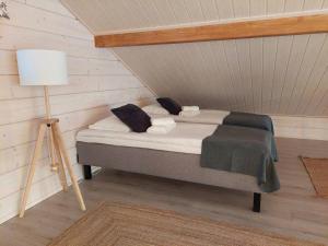 a bedroom with a bed and a lamp in a room at Villa Vasa - new luxury villa next to lake in Meltaus