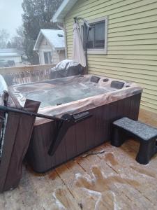 a hot tub sitting outside of a house at Outdoor Hot Tub and Cozy King Bed in Lansing