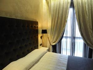 a bedroom with a bed and a window with curtains at Hotel Continental in Turin