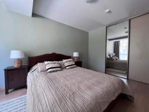 a bedroom with a large bed with two pillows on it at Apartamentai Forest green in Nida