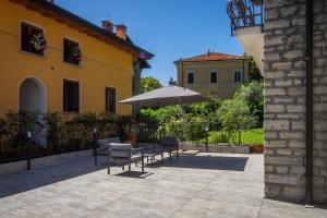 eine Terrasse mit einem Tisch und einem Sonnenschirm in der Unterkunft Villa Senagra Holidays Lake Como in Menaggio