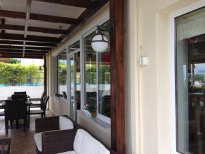 a porch with white furniture and a table and chairs at Alma Hotel in Kamena Vourla