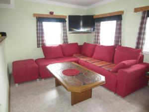 Sala de estar con sofá rojo y mesa de centro en Ferienhaus Wuttijockl, en Oberhaag