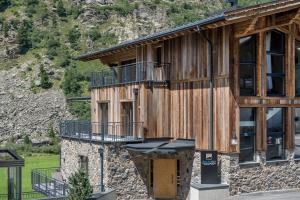 duży drewniany budynek z balkonem w obiekcie Gletscherblick- serviced apartments w mieście Obergurgl