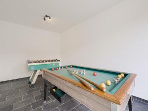 una mesa de billar con bolas y murciélagos. en Modern holiday home in Ronse with garden en Ronse