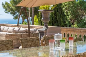 a table with glasses and an umbrella on a patio at Villa Riviera in Costa d'en Blanes