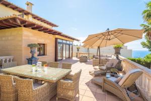 a patio with a table and chairs and an umbrella at Villa Riviera in Costa d'en Blanes