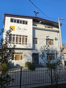 Un bâtiment blanc avec un oiseau en haut dans l'établissement Jules Verne Hostel, à Tachkent