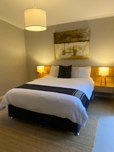 a bedroom with a large bed with two lamps at Island Break Cottages in Cowes