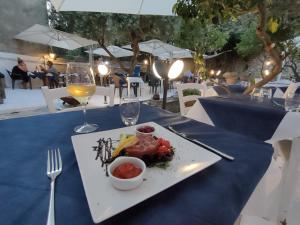 einen Teller mit Essen auf einem Tisch mit einem Glas Wein in der Unterkunft White Lerici in Lerici