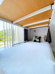 a bedroom with a bed and a large window at Khaolak Mind Home Hostel in Khao Lak