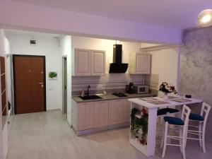 eine Küche mit weißen Schränken, einer Spüle und einer Theke in der Unterkunft Delux Studio Mamaia Nord in Năvodari