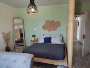Dormitorio con cama con edredón azul y espejo en Peace & View, en Archangelos