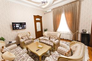 uma sala de estar com sofás e uma mesa em Diyor Gold Hotel em Samarkand
