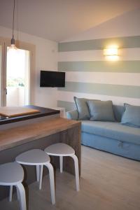 a living room with a blue couch and two stools at Le Quiete Stanze, vacancy houses posto spiaggia in omaggio in Numana