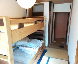 Litera en una habitación con literas y utensilios de cocina en Guesthouse Oasis en Osaka