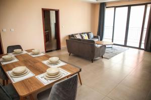 a living room with a wooden table and chairs at PALMVILLAGE MIKOCHENI in Dar es Salaam