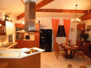 een keuken met een tafel en een zwarte koelkast bij Villa Liamone in Sagone