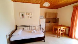 a bedroom with a bed and a table and a kitchen at Zacharogianni Studios in Nikiana