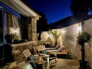 - une terrasse avec une table et des chaises la nuit dans l'établissement Les Rêves d'Eden Gite dans Mas Cévenol -SPA privatif, à Carnoulès