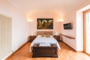 a bedroom with a bed and a tv on the wall at Casale Ianus - Country house with Panoramic View in Sorrento