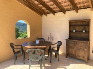 a dining room with a table and chairs and a window at Villa Câline chambres d'hôtes in Vesseaux