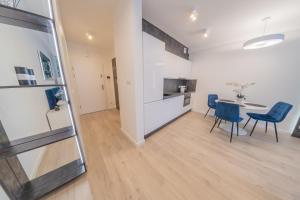 a kitchen and dining room with a table and chairs at Apartament Sapphire Rogowo Pearl in Mrzeżyno