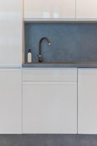 kuchnia ze zlewem i białymi szafkami w obiekcie Apartament Sapphire Rogowo Pearl w mieście Mrzeżyno