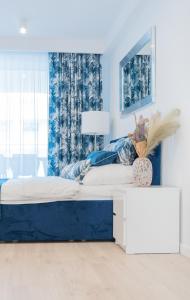 a white and blue bedroom with a large bed at Apartament Sapphire Rogowo Pearl in Mrzeżyno