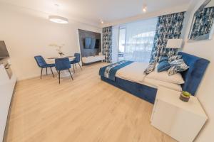 a bedroom with a bed and a table with chairs at Apartament Sapphire Rogowo Pearl in Mrzeżyno