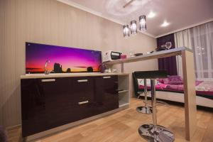 a room with a large screen tv in a bedroom at KvartHaus na 70 let Oktyabrya in Tolyatti
