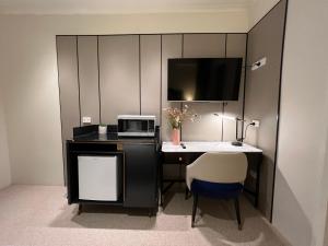 a room with a desk with a microwave and a chair at Lismore City Motor Inn in Lismore