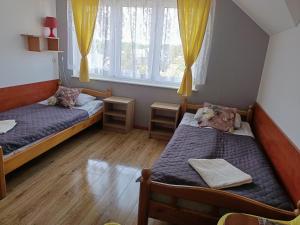 a room with two beds and a window at Pokoje Gościnne u MARCINA- sala zabaw, basen, melex, rowery, grill in Ostrowo