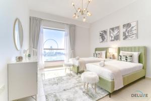 2 Betten in einem Schlafzimmer mit Blick auf das Rad in der Unterkunft Impeccable 2BR at Bahar 2 JBR by Deluxe Holiday Homes in Dubai